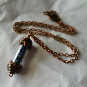 Antique copper leaf-tipped vial pendant on a copper chain with lapis lazuli